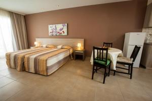a bedroom with a bed and a table and chairs at Crystallo Apartments in Paphos