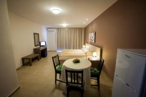 a room with a table and chairs and a kitchen at Crystallo Apartments in Paphos