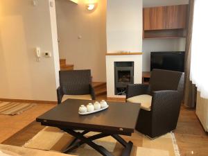 a living room with a table and chairs and a fireplace at Vila Danin with free garage,Stari grad in Sarajevo