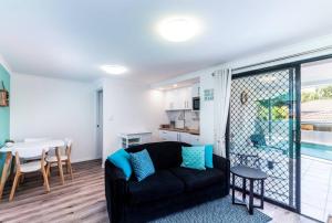 a living room with a black couch and a table at Central Location - Noosa Address - Pet Friendly in Noosa Heads