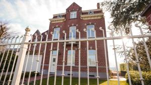 贝拉克尔Villa Corthals的前面有围栏的建筑物