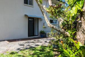 a white house with a tree in front of it at Central Location - Noosa Address - Pet Friendly in Noosa Heads