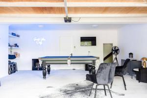 a room with a pool table and two chairs at BERRIMA LUXE - Noosa Hill Home - Heated Pool in Noosa Heads