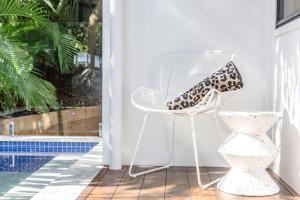 a white chair with a leopard print shoe sitting on it at BERRIMA LUXE - Noosa Hill Home - Heated Pool in Noosa Heads