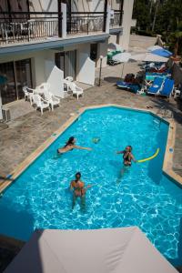 three people are playing in a swimming pool at Crystallo Apartments in Paphos