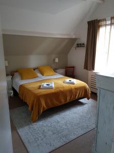 a bedroom with a bed with two towels on it at Hotel De Waag in Bergen