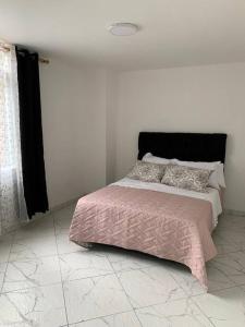 - une chambre avec un lit doté d'une couverture et d'oreillers roses dans l'établissement Apartamento cerca a Plaza Mayor en Medellín, à Medellín