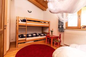 a bedroom with bunk beds and a red rug at Haus Evelin in Kundl