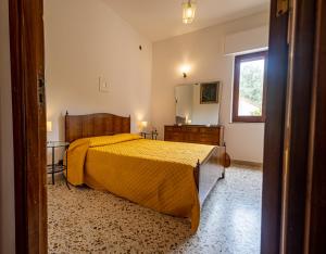 una camera con letto e copriletto giallo di Terrazza vista mare-Cefalù a Cefalù