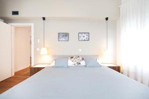 ein Schlafzimmer mit einem großen weißen Bett mit blauen Kissen in der Unterkunft Summer Breeze apartment in Zadar