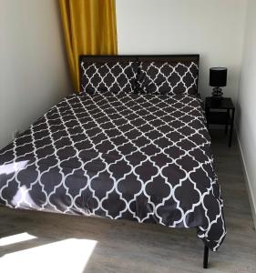 a bedroom with a bed with a black and white bedspread at Sancerre Sunflower - Tournesol de Sancerre in Sancerre