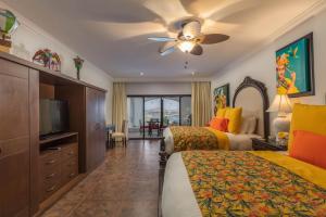 カボ・サン・ルーカスにあるHacienda Encantada Resort & Spaのベッド2台、薄型テレビが備わるホテルルームです。