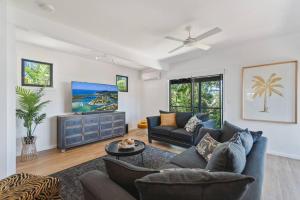 ein Wohnzimmer mit Sofa und Fernseher in der Unterkunft PACIFIC Stunning Coastal Home The Perfect Family Getaway in Sunshine Beach
