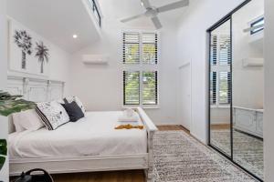 ein weißes Schlafzimmer mit einem Bett und Fenstern in der Unterkunft PACIFIC Stunning Coastal Home The Perfect Family Getaway in Sunshine Beach + 30 Fotos