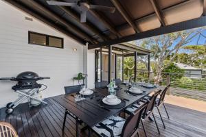 ein Esszimmer mit Tisch und Stühlen auf einer Terrasse in der Unterkunft PACIFIC Stunning Coastal Home The Perfect Family Getaway in Sunshine Beach