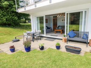 a patio with a table and chairs and potted plants at Swn Y Mor in Saundersfoot