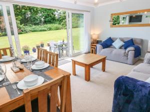 a living room with a table and a dining room at Swn Y Mor in Saundersfoot