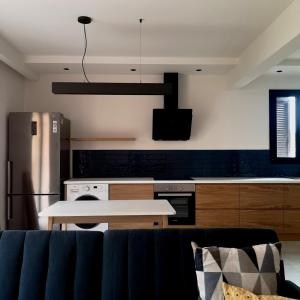 una cucina con divano blu in una camera di Eirini's Apartment a Análipsis
