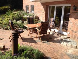 a patio with a wooden table and chairs at Fewo Eckernförde mit Meerblick in Eckernförde