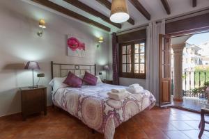 ein Schlafzimmer mit einem Bett und einem großen Fenster in der Unterkunft Casa de Teones con piscina privada in Montecorto + 24 Fotos