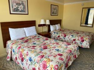 a hotel room with two beds with floral sheets at Downbeach Inn in Atlantic City