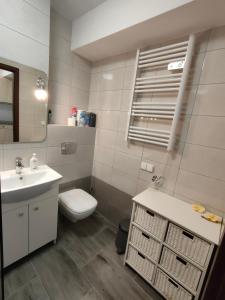 a white bathroom with a sink and a toilet at Apartament Alex in Mikołajki