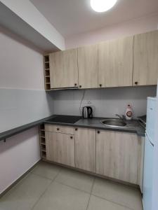a kitchen with wooden cabinets and a sink at Apartament Alex in Mikołajki