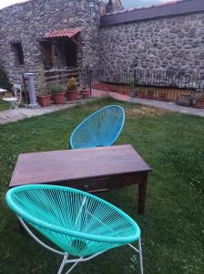 uma mesa de madeira e duas cadeiras num quintal em El Rincon De Zaldierna em Zaldierna