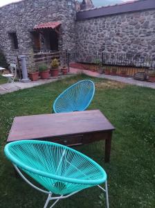 a wooden table and two chairs in a yard at El Rincon De Zaldierna in Zaldierna