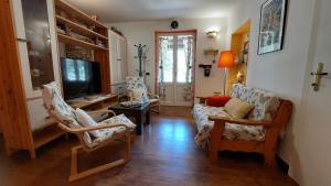 salon z 2 krzesłami i telewizorem w obiekcie Locazione turistica nel verde Civita di Bagnoregio w mieście Lubriano