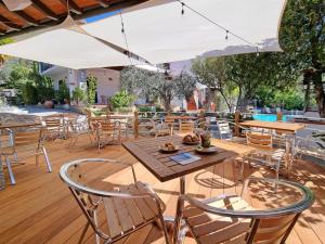 a patio with tables and chairs and an umbrella at Eco Hotel Montemerlo in Fetovaia
