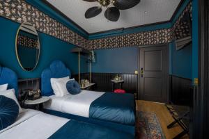 a blue room with two beds and a mirror at Craves in Brussels