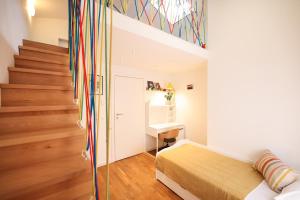 a room with a bed and a desk and stairs at Summer Breeze apartment in Zadar