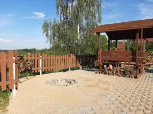 a wooden fence with a pavilion and a fire pit at Trzy Szczęścia in Szklarska Poręba