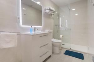 La salle de bains blanche est pourvue d'un lavabo et de toilettes. dans l'établissement Reinapart Valencia Beach, à Valence