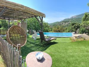 un patio con una silla y una piscina en La roulotte, en Carbuccia