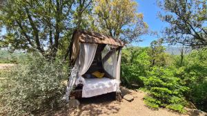 ein altes Bett mitten auf einem Feld in der Unterkunft La roulotte au coeur du maquis in Carbuccia