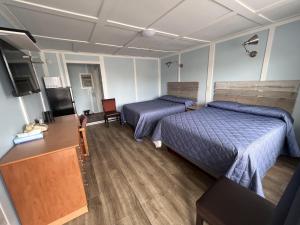 Zimmer mit 2 Betten, einem Schreibtisch und einem TV in der Unterkunft Elect Inn 5 in Cornwall