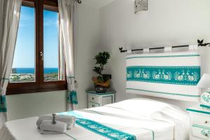 um quarto com uma cama e vista para o oceano em Hotel Trinità dei Corsari em Torre Dei Corsari
