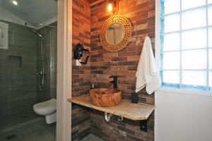 a bathroom with a sink and a brick wall at Efi's Home in Vourvourou