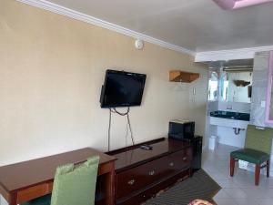 a room with a desk and a television on the wall at Downbeach Inn in Atlantic City