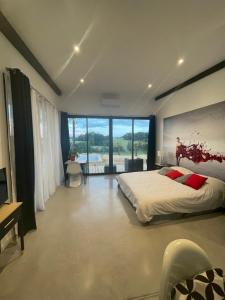 1 dormitorio con cama grande y ventana grande en VILLA EDEN, en Perchède