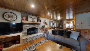 sala de estar con sofá y chimenea en The Ranch Cabin in Great Smoky Mountain, en Sevierville