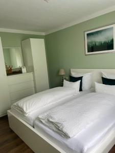 フロイデンシュタットにあるBlackforest Apartmentのベッドルーム(白いシーツを使用した大型ベッド1台付)