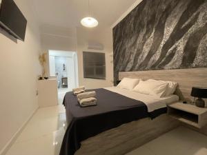 a bedroom with a large bed with a large painting on the wall at Jz Plus e'Bella in Rhodes Town