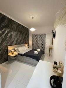 een slaapkamer met een bed en een schilderij aan de muur bij Jz Plus e'Bella in Rhodos-stad