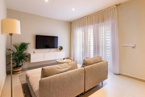 ein Wohnzimmer mit einem Sofa und einem Flachbild-TV in der Unterkunft Otrobanda Apartment in Willemstad