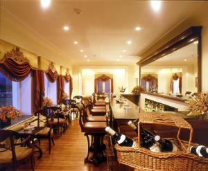 ein Restaurant mit einer Bar mit Tischen und Stühlen in der Unterkunft The LaLit Grand Palace Srinagar in Srinagar