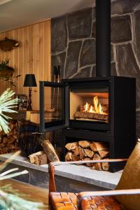 a stove in a living room with a fireplace at Bluebird Sunapee in Mount Sunapee