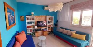 a blue living room with a couch and a tv at Apartment sea view Marija Franić in Slatine